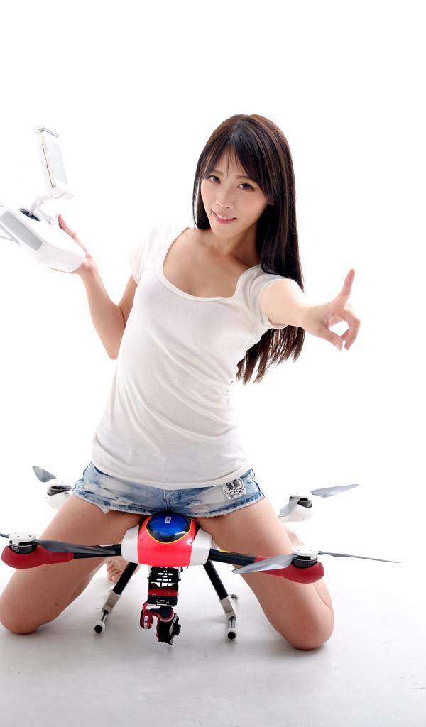 Девушка азиатка с квадрокоптером на белом фоне