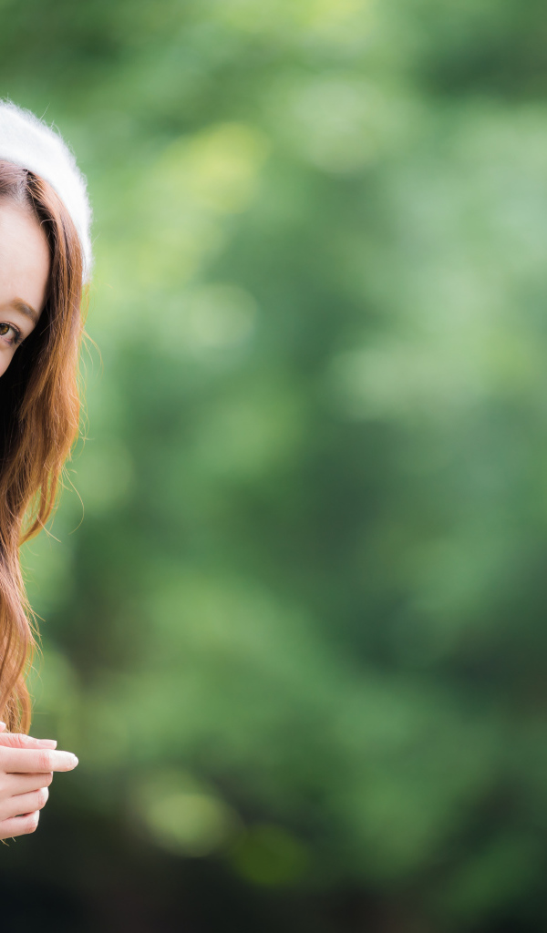 Азиатка в берете выглядывает из окна