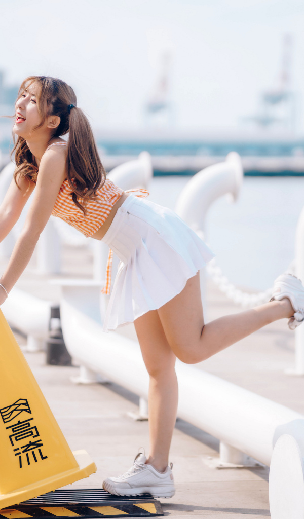 Азиатка с короткой белой юбке у воды 