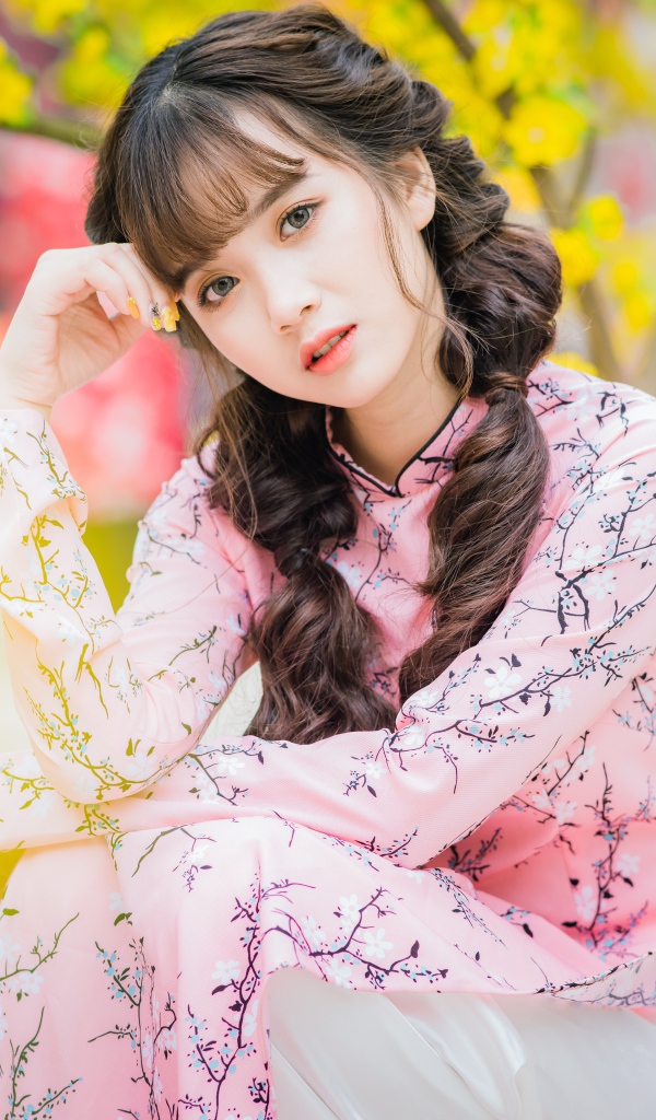 Красивая девушка азиатка в красивом розовом наряде в парке