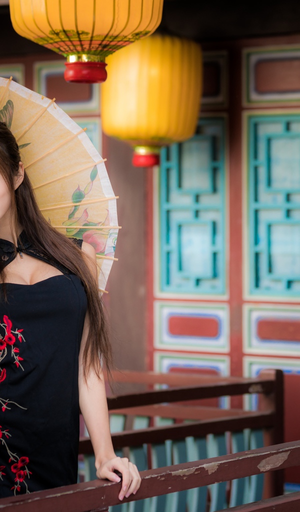 Красивая девушка азиатка в черном платье с зонтом