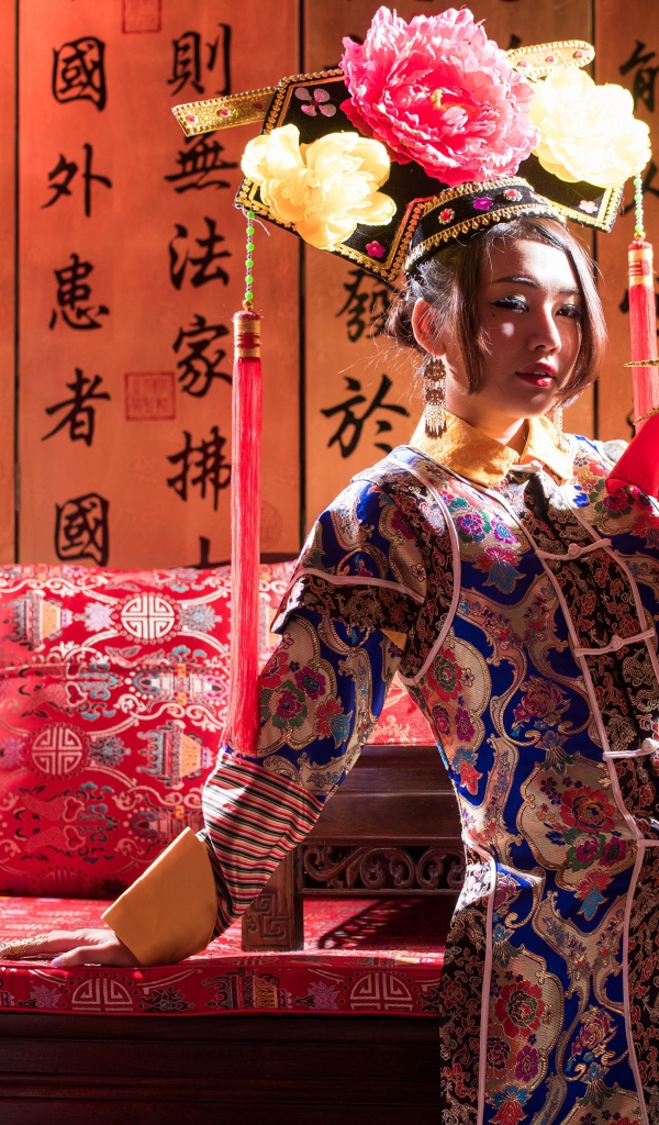 Красивая девушка азиатка в национальном костюме на диване