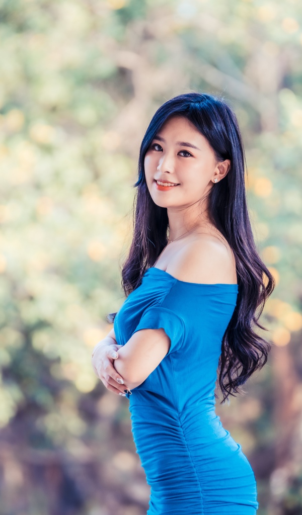 Красивая девушка азиатка с милой улыбкой в голубом платье 