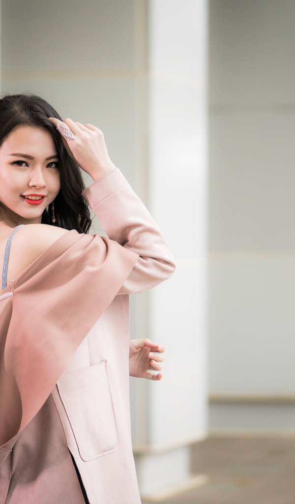 Красивая девушка азиатка с длинными волосами в розовом пальто 