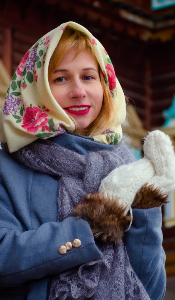 Красивая русская женщина в платке стоит у дома