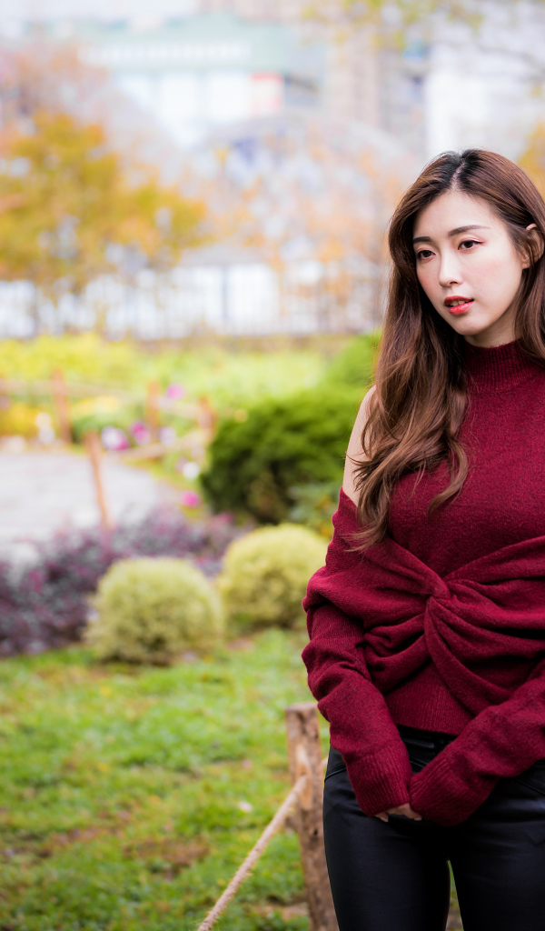 Красивая девушка азиатка в красном наряде в парке