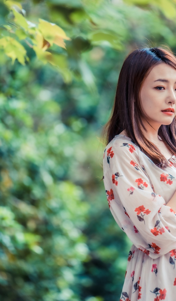 Красивая девушка азиатка в платье в парке