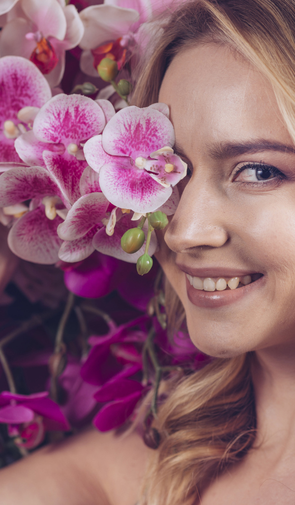 Красивая девушка блондинка с цветами орхидеи