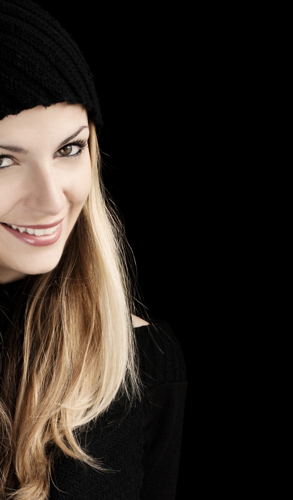 Красивая блондинка в шапке на черном фоне