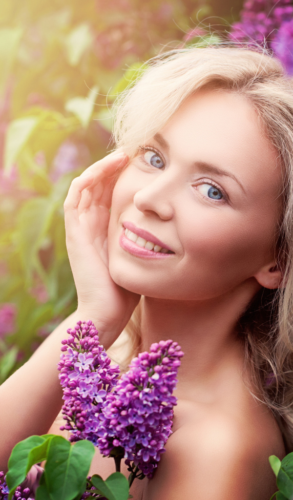 Красивая голубоглазая девушка блондинка в цветах сирени