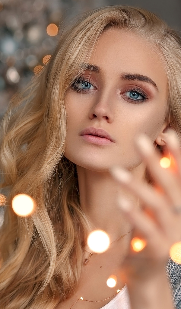 Красивая голубоглазая блондинка с гирляндой в руке