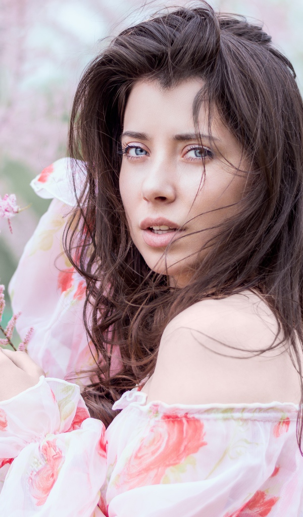 Красивая голубоглазая девушка в розовых зарослях 