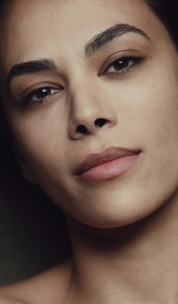 Красивая кареглазая девушка лежит на диване 