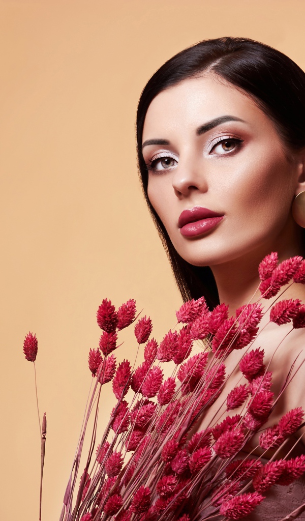 Красивая брюнетка в букетом красных цветов 