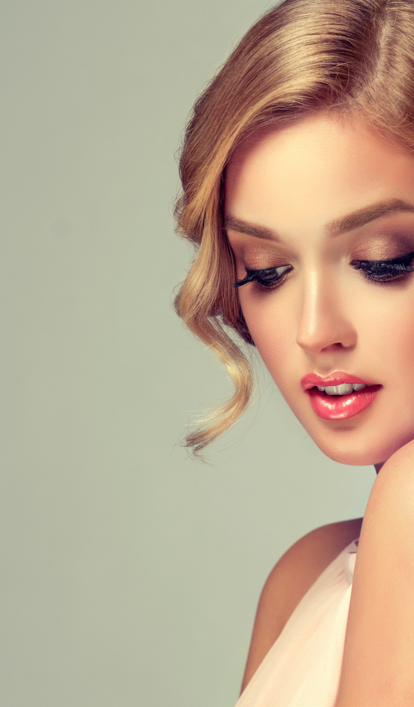 Красивая милая девушка со стильной прической на сером фоне