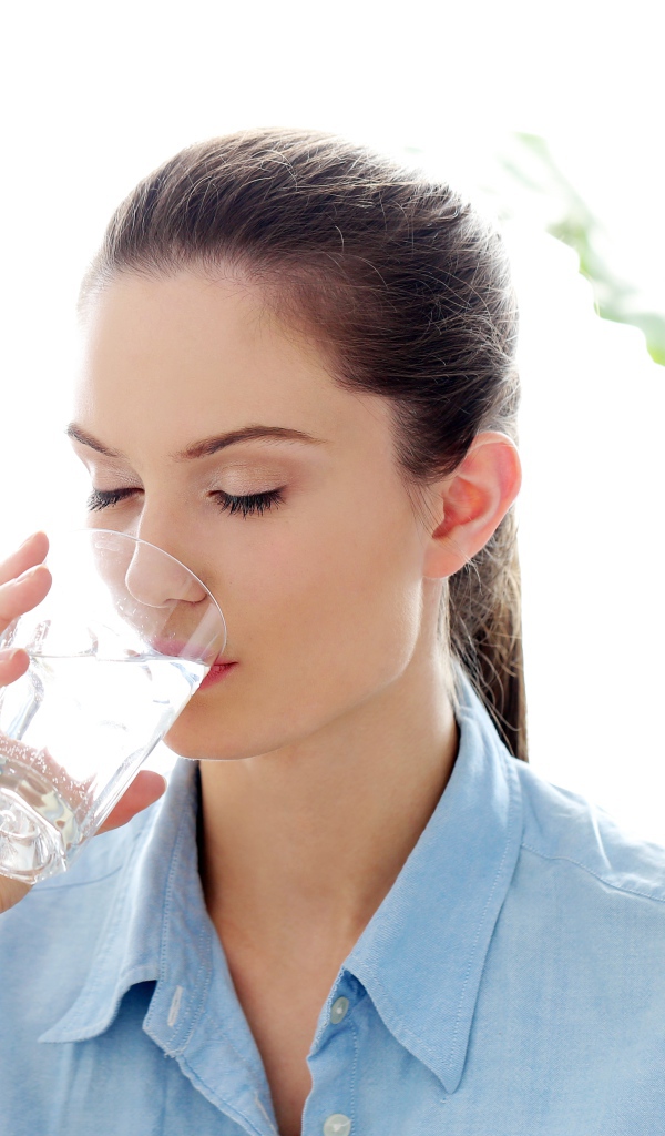 Красивая девушка пьет воду утром