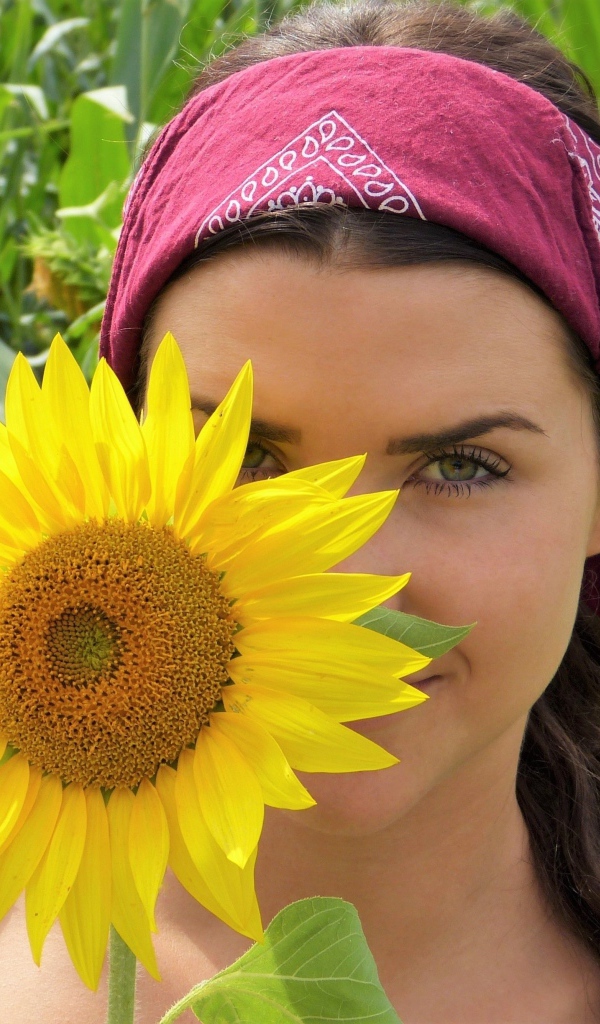 Красивая девушка держит в руках цветок подсолнуха