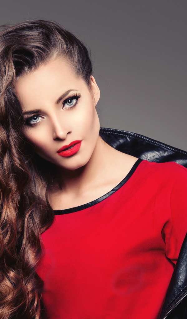 Красивая девушка в черной кожаной куртке и красном свитере