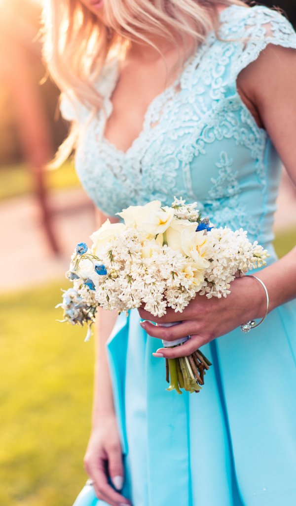 Красивая девушка в голубом платье с букетом в руке