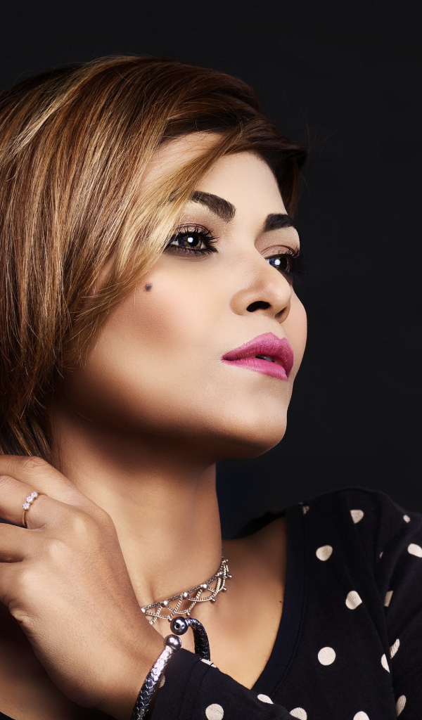 Красивая девушка в платье в горох на черном фоне