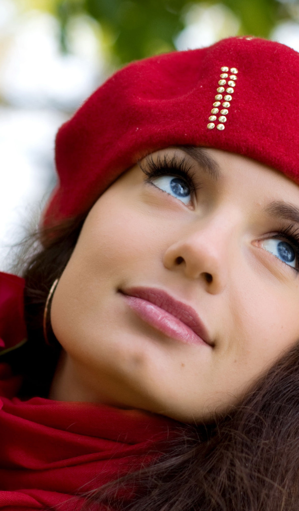 Красивая девушка в красном берете с букетом роз у дерева