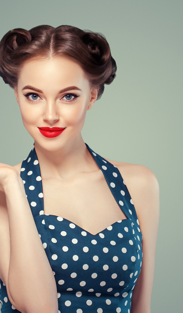 Красивая девушка в платье в горошек на сером фоне