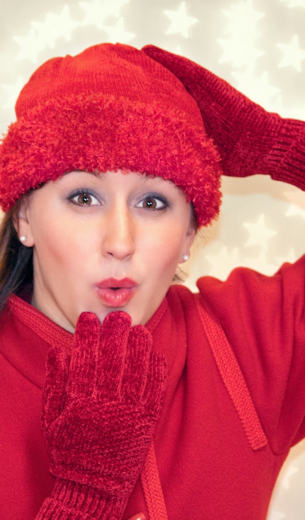 Красивая девушка в красном шлет воздушный поцелуй