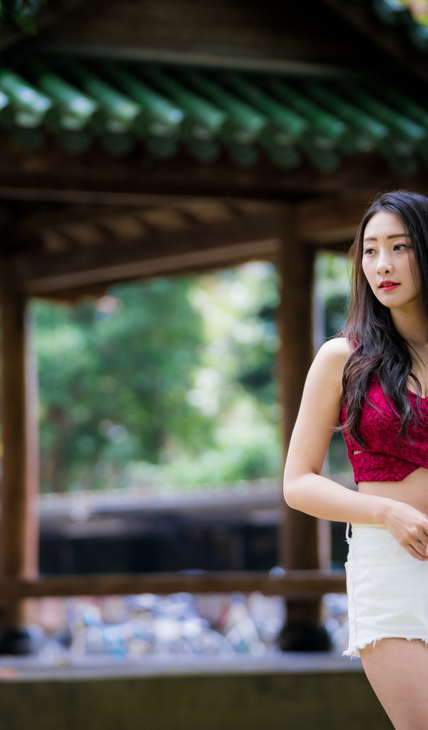 Красивая девушка в белых шортах в парке