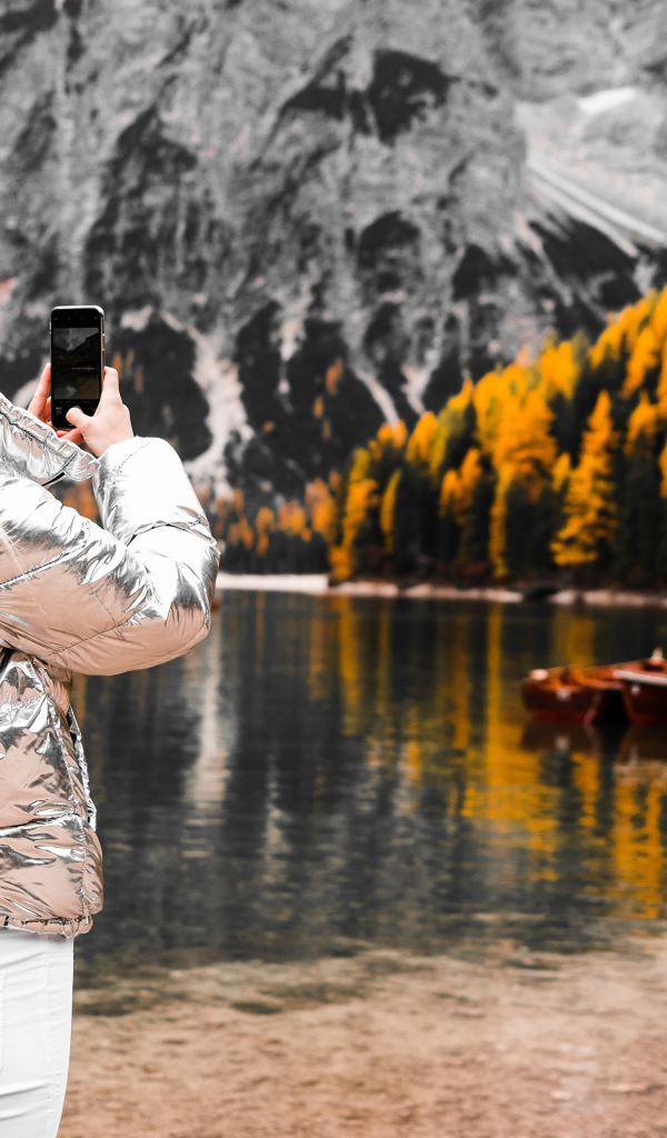 Красивая девушка делает фото гор на телефон 