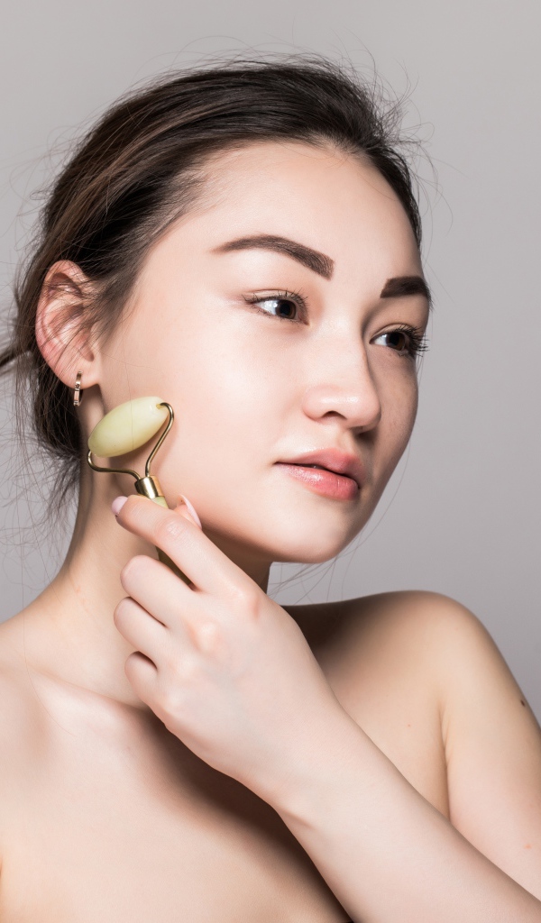 Красивая девушка разглаживает кожу лица