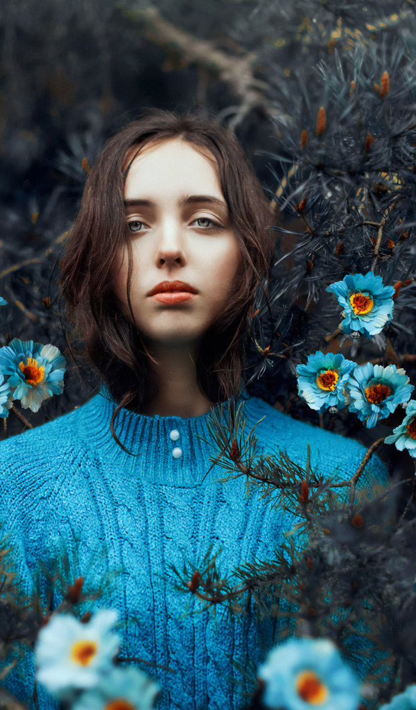 Красивая девушка колючих зарослях с голубыми цветами