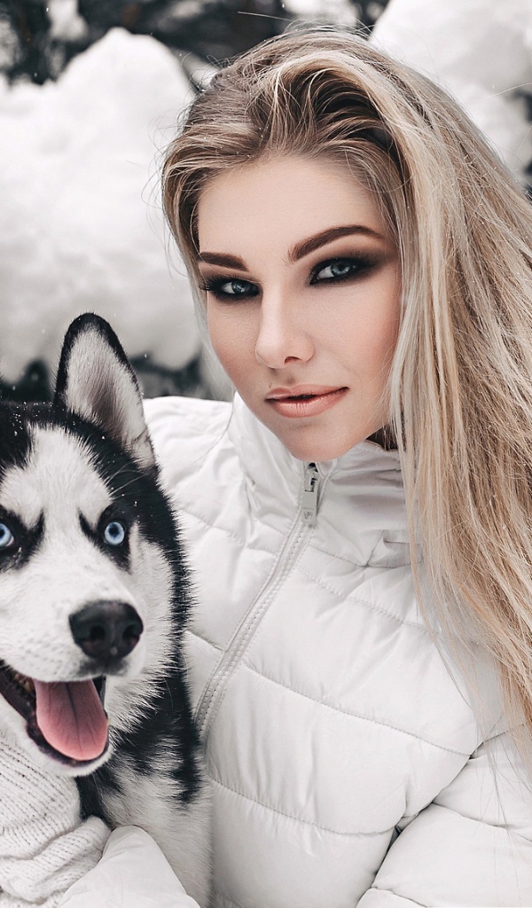 Красивая девушка с хаски у заснеженной ели