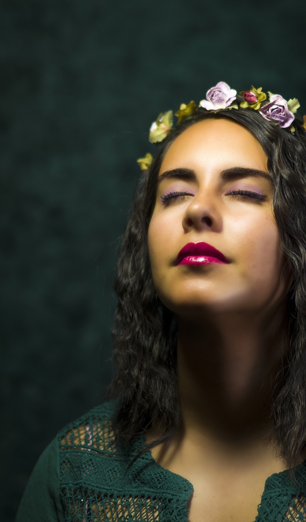 Красивая девушка с закрытыми глазами с венком на голове 