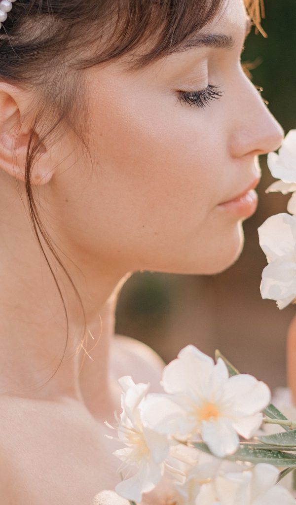 Красивая девушка с белыми цветами в руке