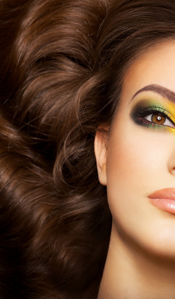 Красивая длинноволосая девушка с ярким макияжем на глазах 