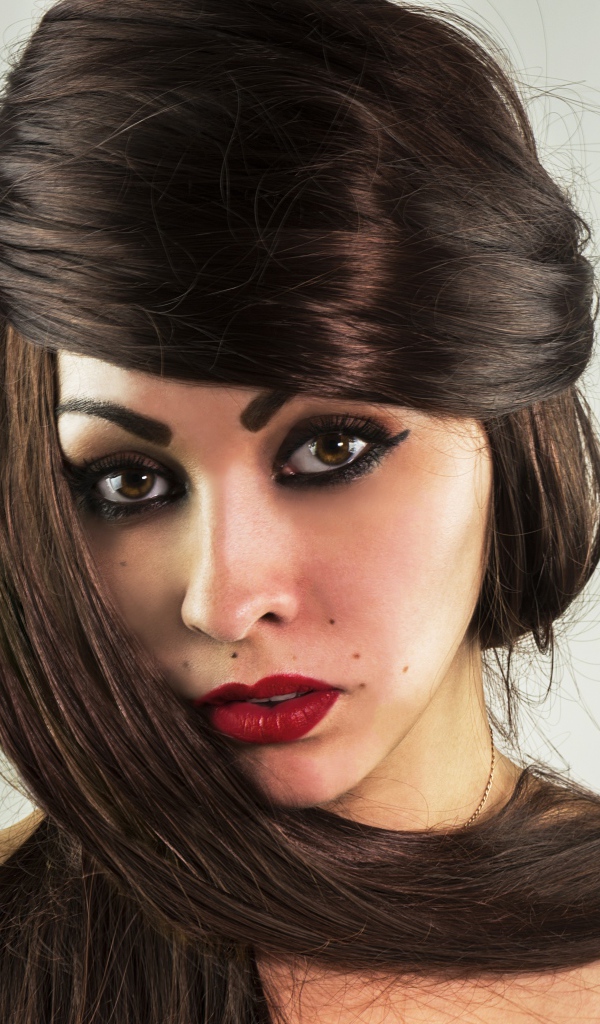 Красивые длинные волосы у девушки с накрашенным лицом