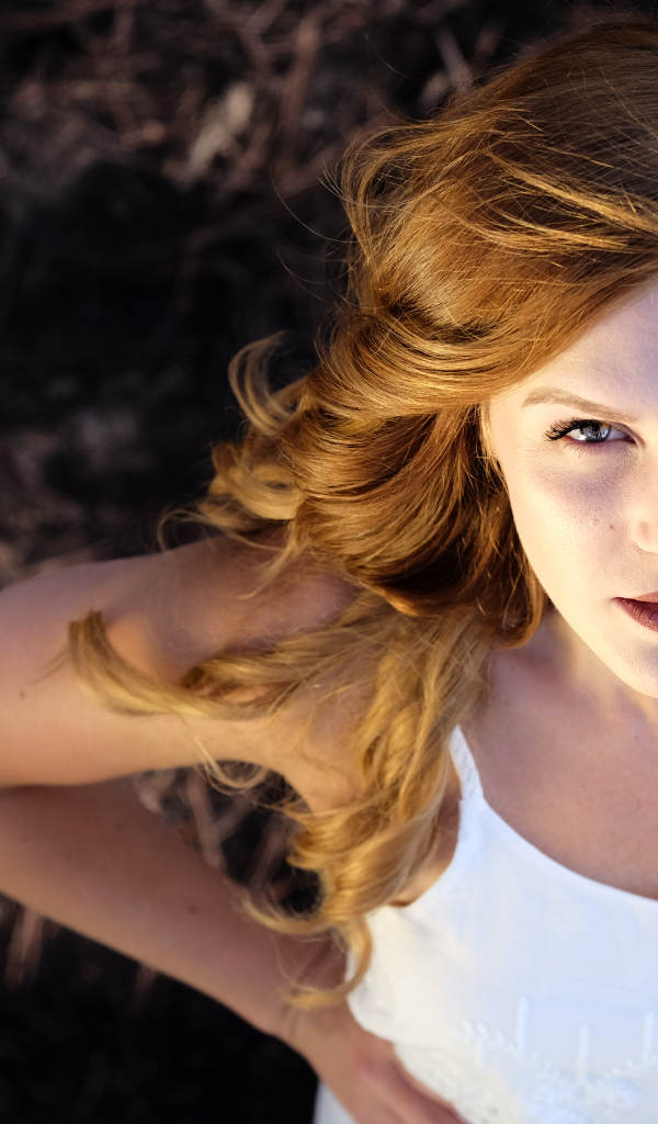 Красивый взгляд рыжеволосой девушки в белом платье