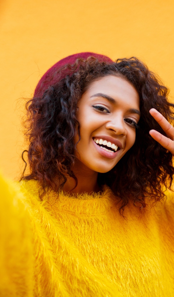 Красивая девушка мулатка в желтом свитере 