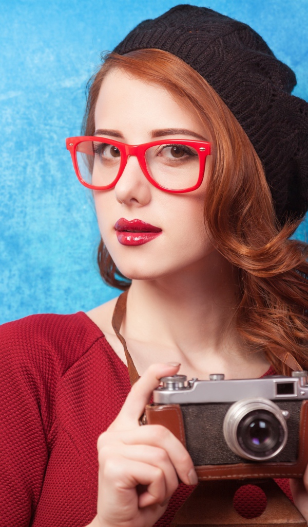 Красивая рыжеволосая девушка в черном берете с фотоаппаратом в руках 