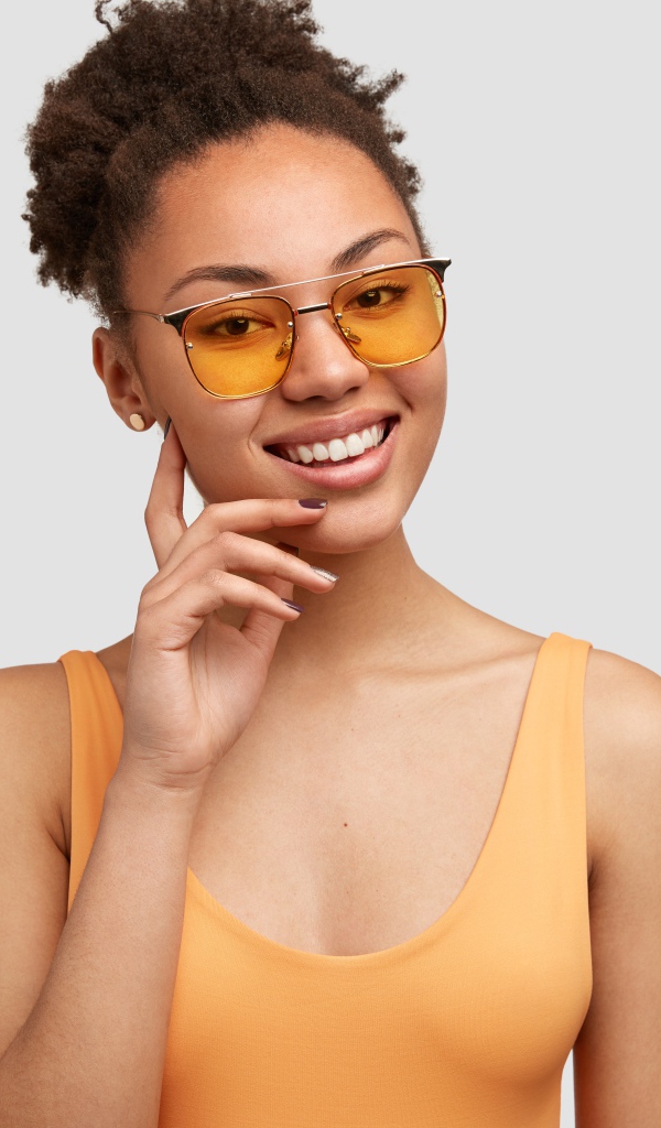 Красивая улыбающаяся темнокожая девушка в солнечных очках