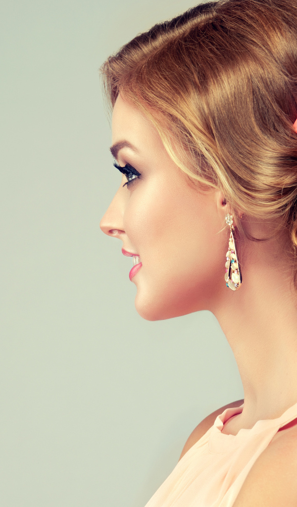 Красивая свадебная прическа у молодой девушки на сером фоне 