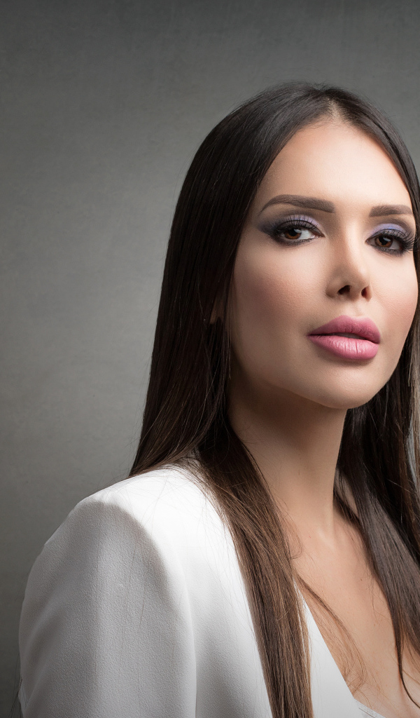 Блондинка с красивым макияжем на сером фоне