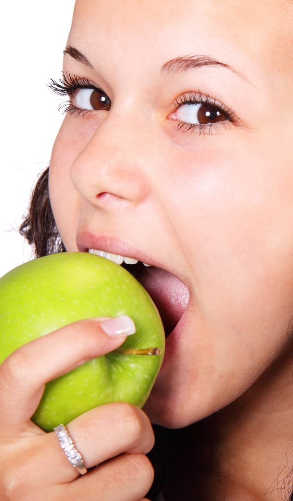 Brown-eyed girl eating a green apple