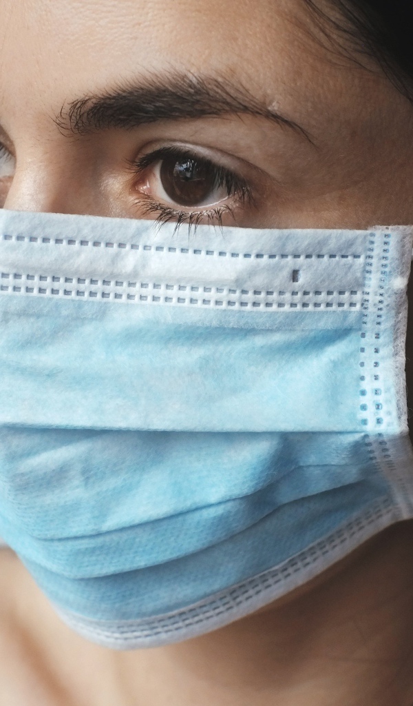 Кареглазая девушка в медицинской маске 