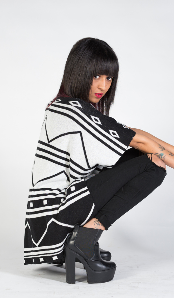 Брюнетка сидит на корточках 