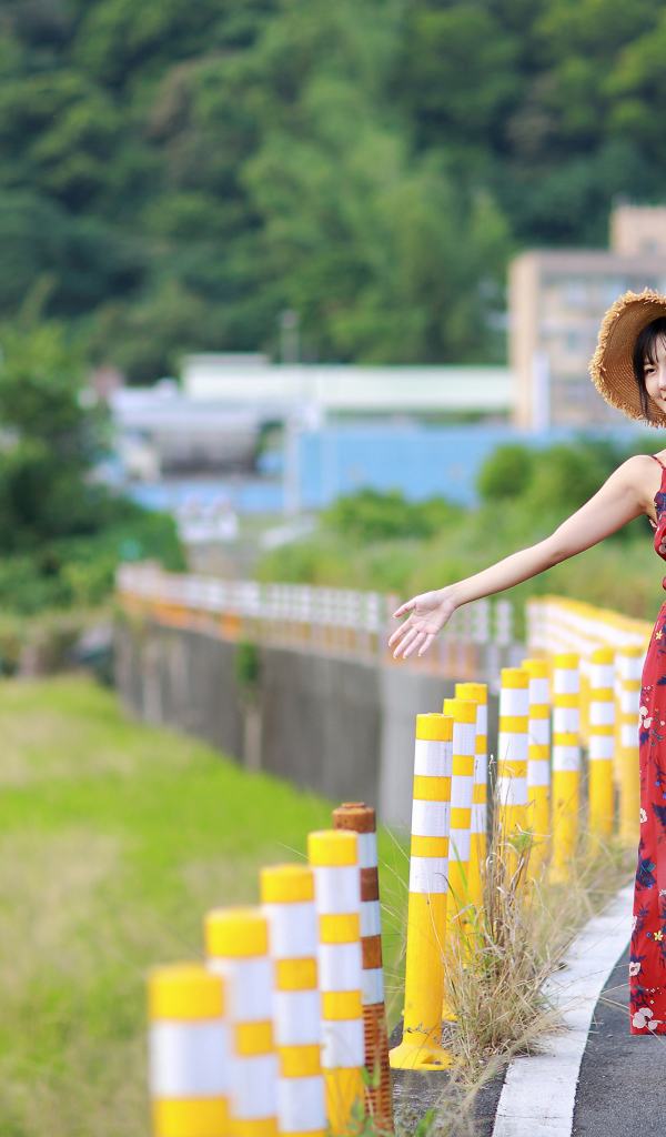 Веселая девушка азиатка в цветастом сарафане 