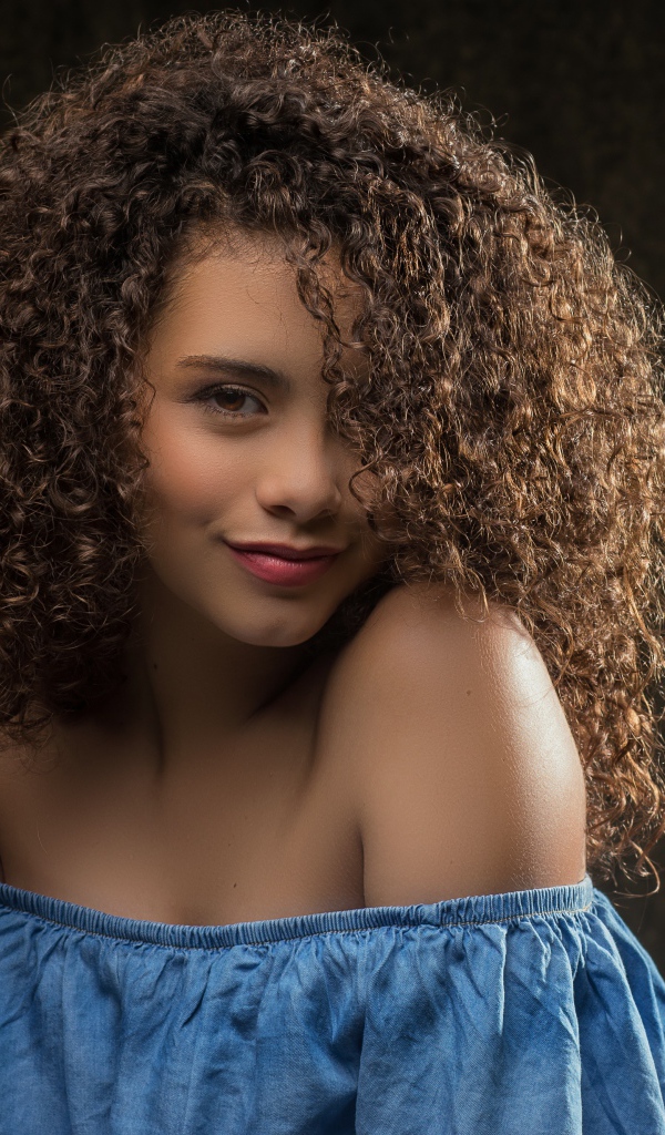 Милая кудрявая девушка в платье