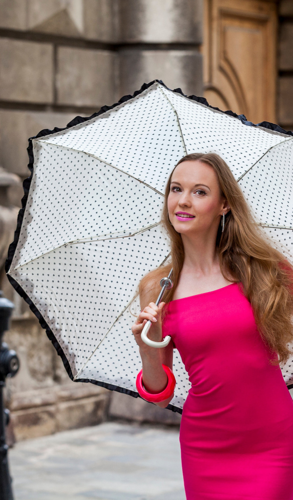 Милая девушка в розовом платье с зонтом в руках 