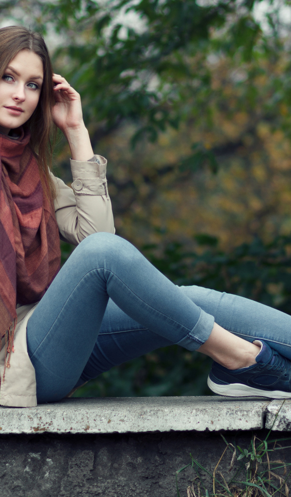 Милая девушка в куртке и синих джинсах 