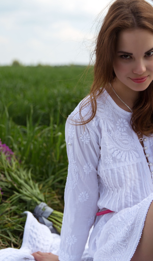 Милая девушка в белом на пикнике на поле